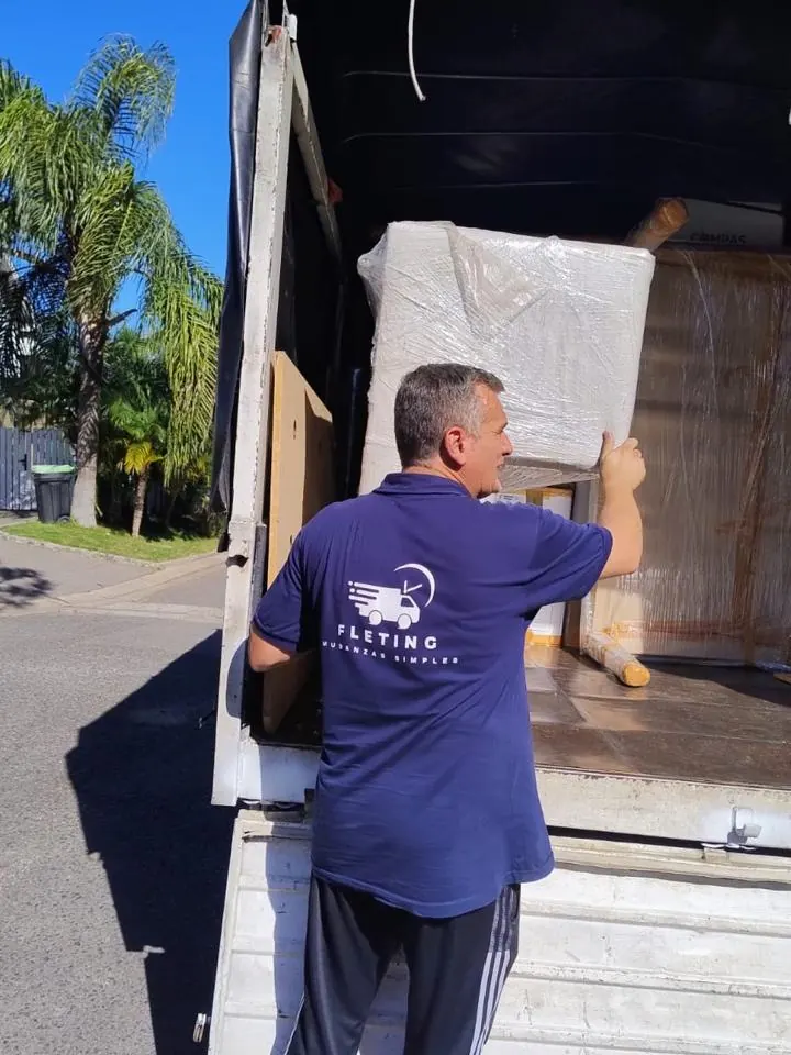 Operario de Fleting cargando un mueble envuelto en el camión
